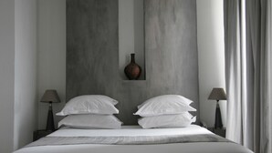 A modern hotel room with a large bed, two bedside lamps, and a vase on the headboard. - Le Ryad Boutique Hôtel (Marseille)