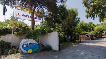 A sign for "Campion La Focetta Sicula" with a colorful mural on a wall.