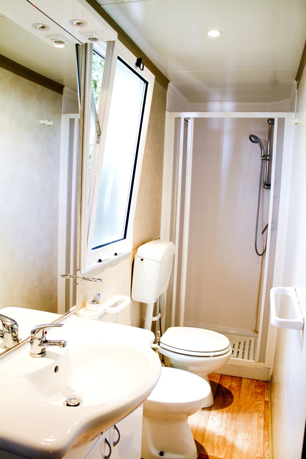 Ein kleines Badezimmer mit Waschbecken, Toilette und Dusche.
