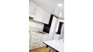 Een moderne keuken met witte kastjes, een roestvrijstalen spoelbak en een wit aanrecht.