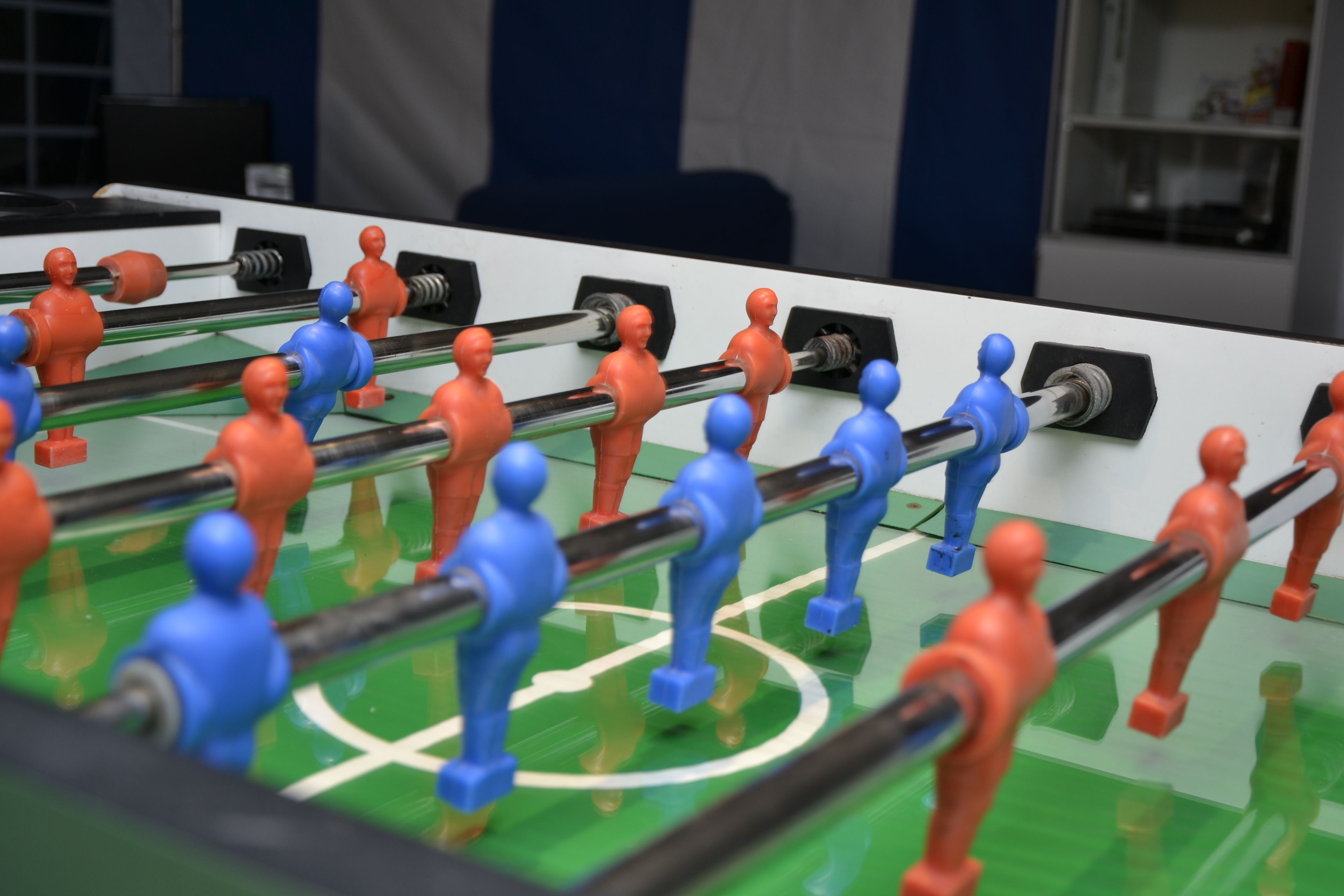 Ein Kicker mit roten und blauen Spielfiguren.