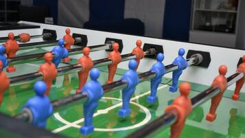 Ein Kicker mit roten und blauen Spielfiguren.