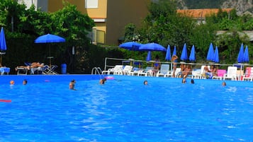 En sÀsongsöppen utomhuspool, parasoller och solstolar