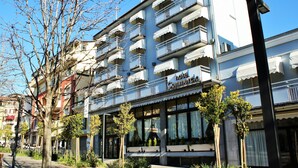 A hotel with multiple balconies, large windows, and a sign indicating it is a commercial hotel. - Hotel Ristorante Commercio (Salò)