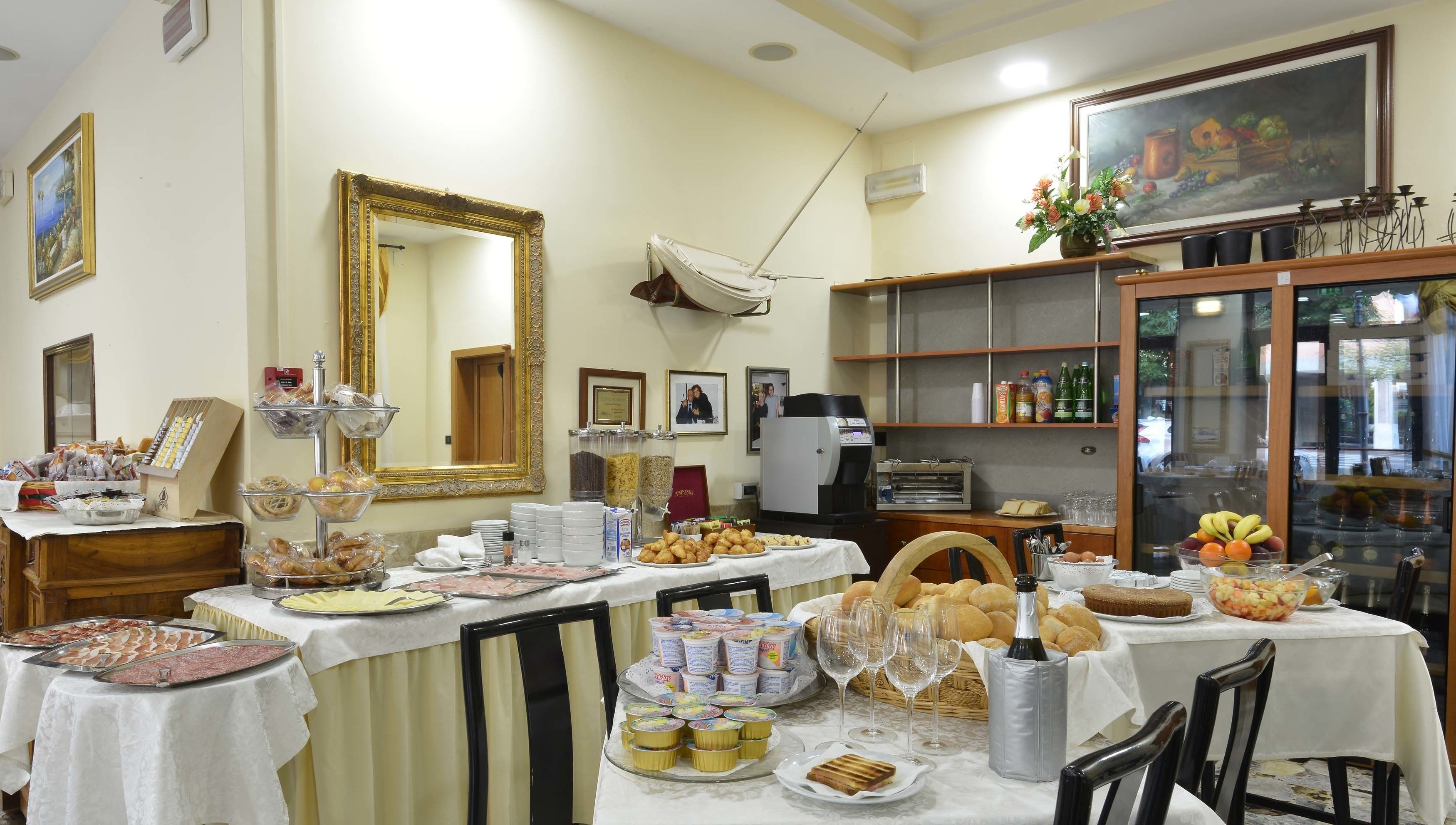 Un espace repas avec des tables dressées pour le repas, une machine à café et un réfrigérateur.