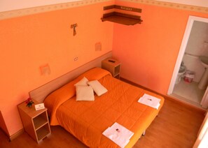 Cubrecamas, escritorio y espacio para trabajar con laptop 