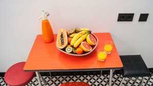 A table with a fruit bowl, a spray bottle, and two glasses of orange juice. - Colosseum Garden (Rome)