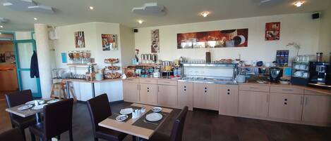 A restaurant with a counter, seating area, and various food and drink items.