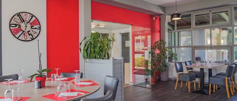 Un comedor moderno con una mesa redonda, sillas y plantas en macetas.