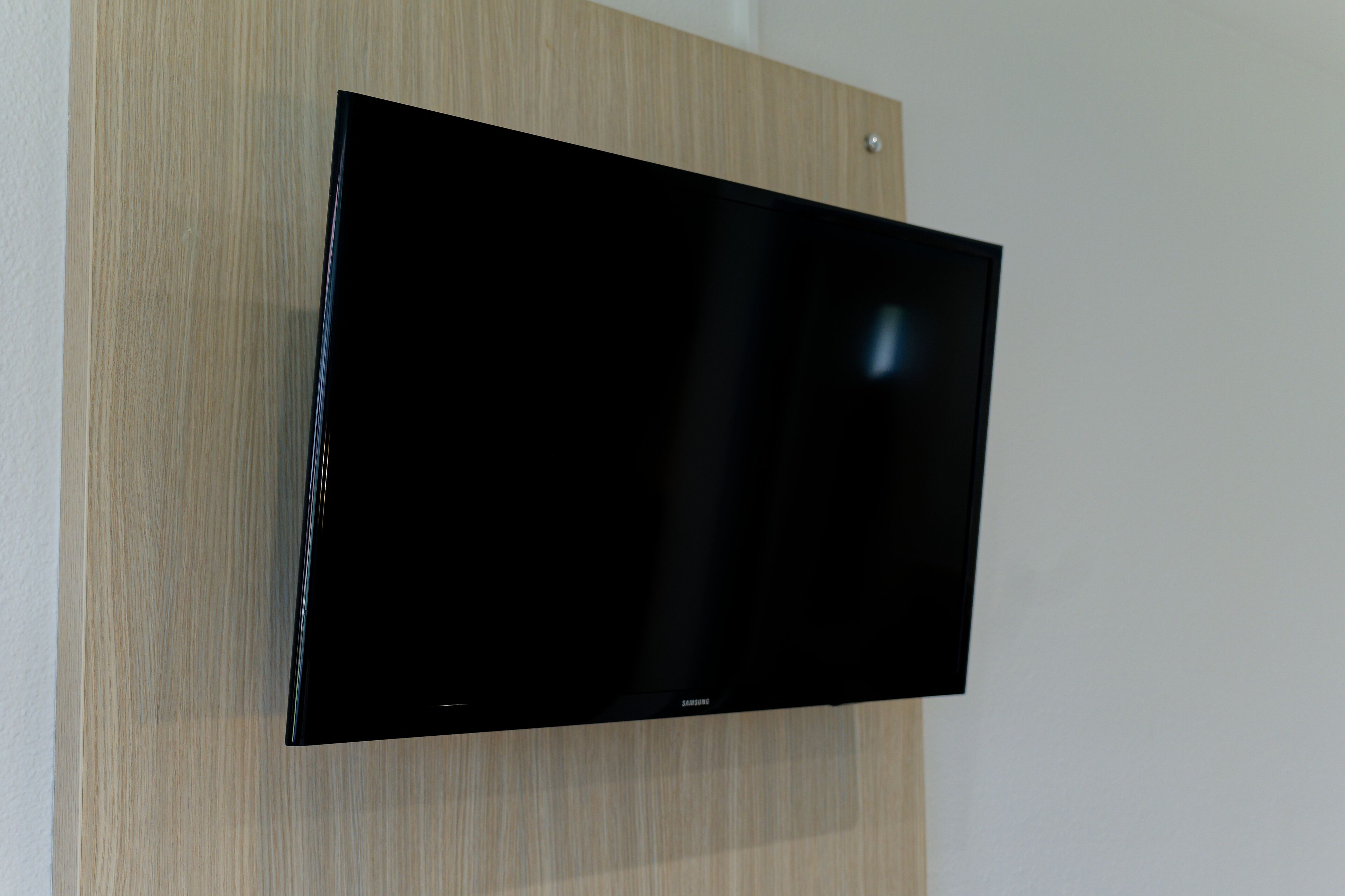 Un televisor de pantalla plana montado en una pared de madera.