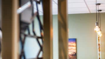 A modern interior with a hanging light fixture and a painting on the wall.