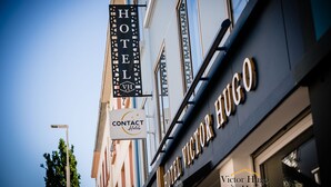 A hotel sign with "HOTEL VICTOR HUGO" and a contact sign for "HOTELS".