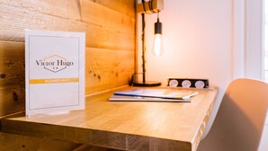 A wooden desk with a framed sign, a lamp, and a chair.