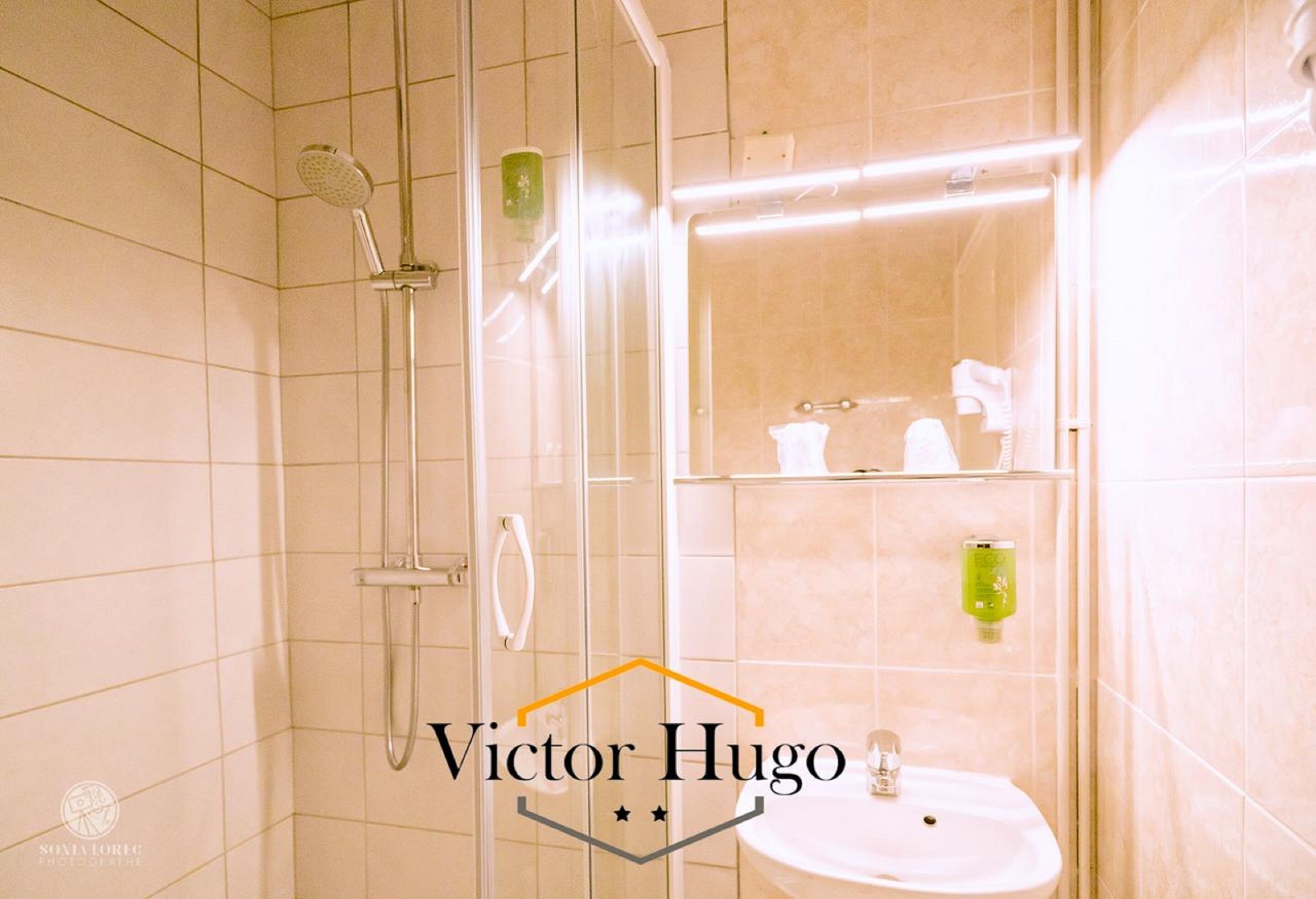 A modern bathroom with a glass-enclosed shower, a white sink, and a mirror above the sink.