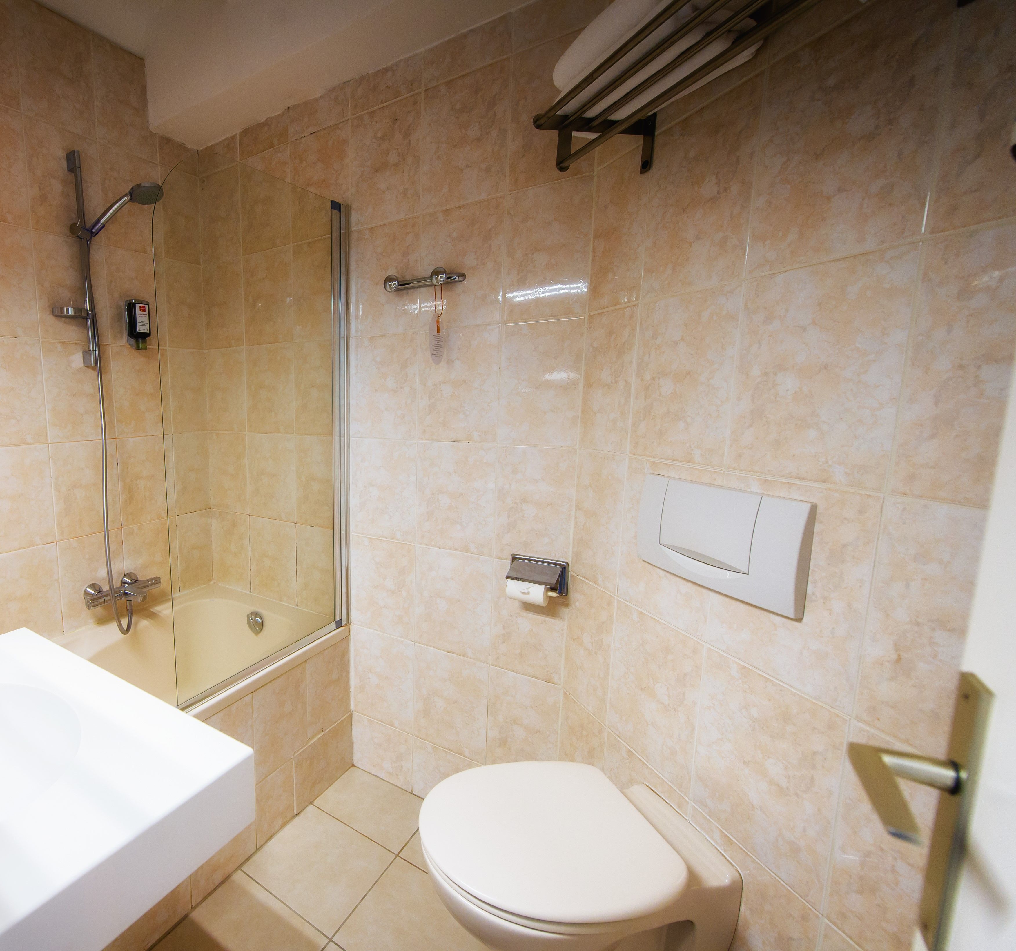 A bathroom with a glass-enclosed shower, a white toilet, and a white sink.