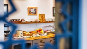 A breakfast buffet with various food items and a coffee machine. - Victor Hugo (Lorient)