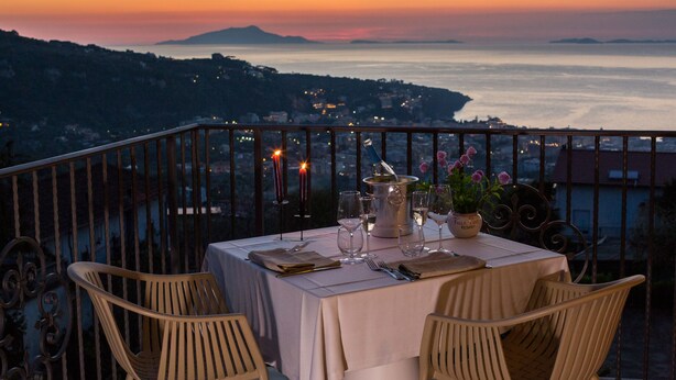 A table set for two with a view of the sea at sunset. - Villa Pane Resort (Sorrento)