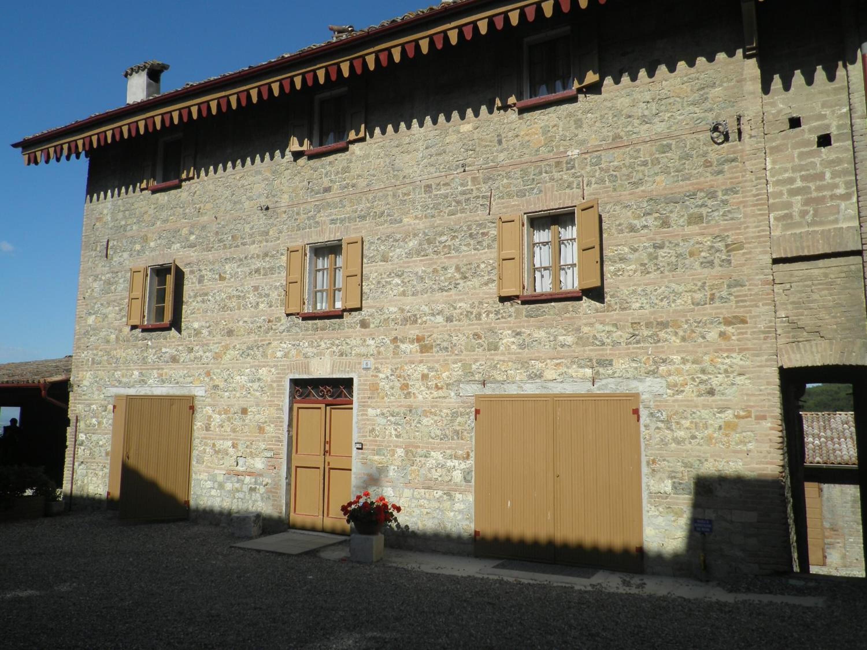 A stone building with two large wooden doors, a small window, and a decorative awning.