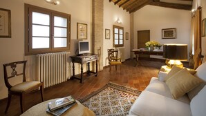 A cozy living room with a fireplace, a sofa, a coffee table, and a television. - Cavazzone (Viano)