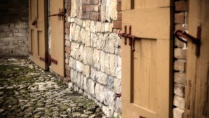 A stone wall with wooden doors. - Cavazzone (Viano)