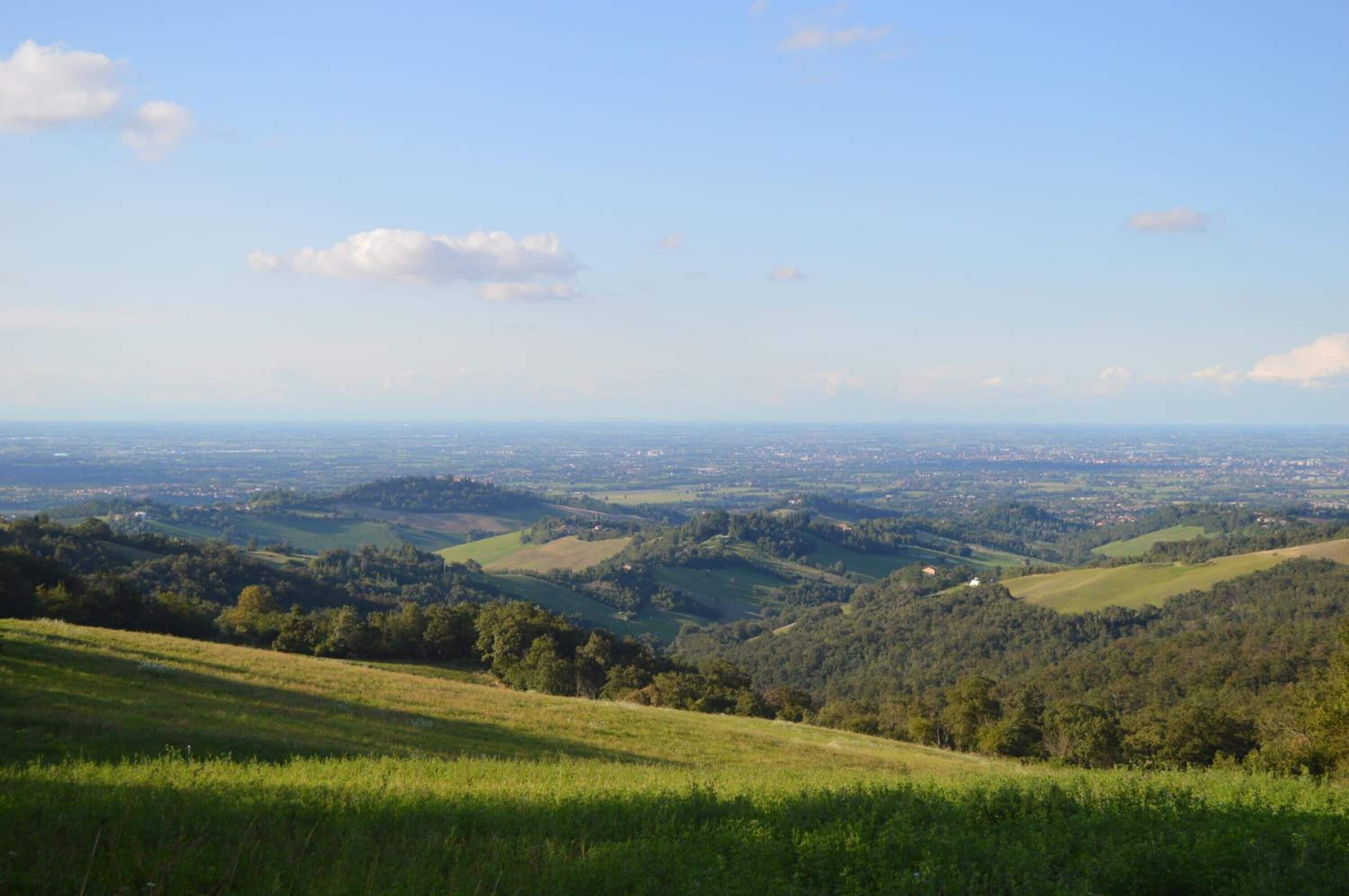 Vista panorámica de un paisaje montañoso con un pueblo en la lejanía.