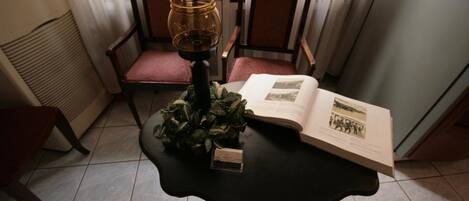 Una habitación con una mesa, sillas, un libro y una lámpara.