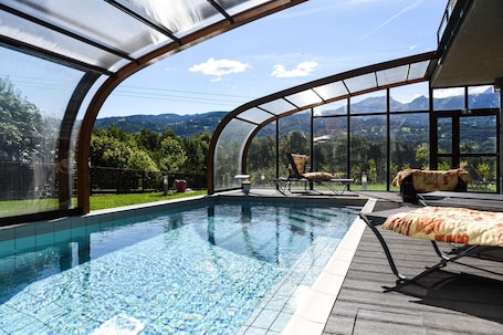 Una piscina techada, sillones reclinables de piscina
