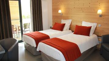 Habitación de hotel con dos camas, un escritorio y una silla.