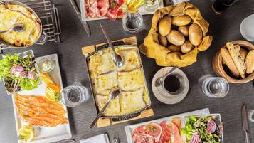 Variedad de alimentos, como salmón, pan y un plato de queso, sobre una mesa.