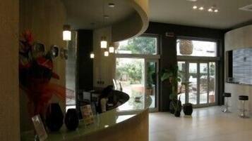 Un espace d’accueil doté d’un comptoir incurvé, d’un bureau de réception et d’une grande fenêtre offrant une vue sur l’extérieur.
