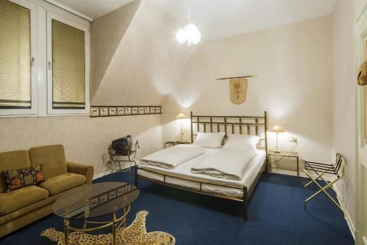 Ein Schlafzimmer mit einem Bett, einem Schlafsofa, einem kleinen Tisch und einer Lampe.