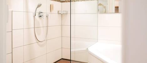 Un baño moderno con cabina de ducha de vidrio, inodoro blanco y bañera.
