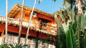 A traditional building with a tiled roof, surrounded by lush tropical vegetation. - Pousada Casa Cactus (Búzios)