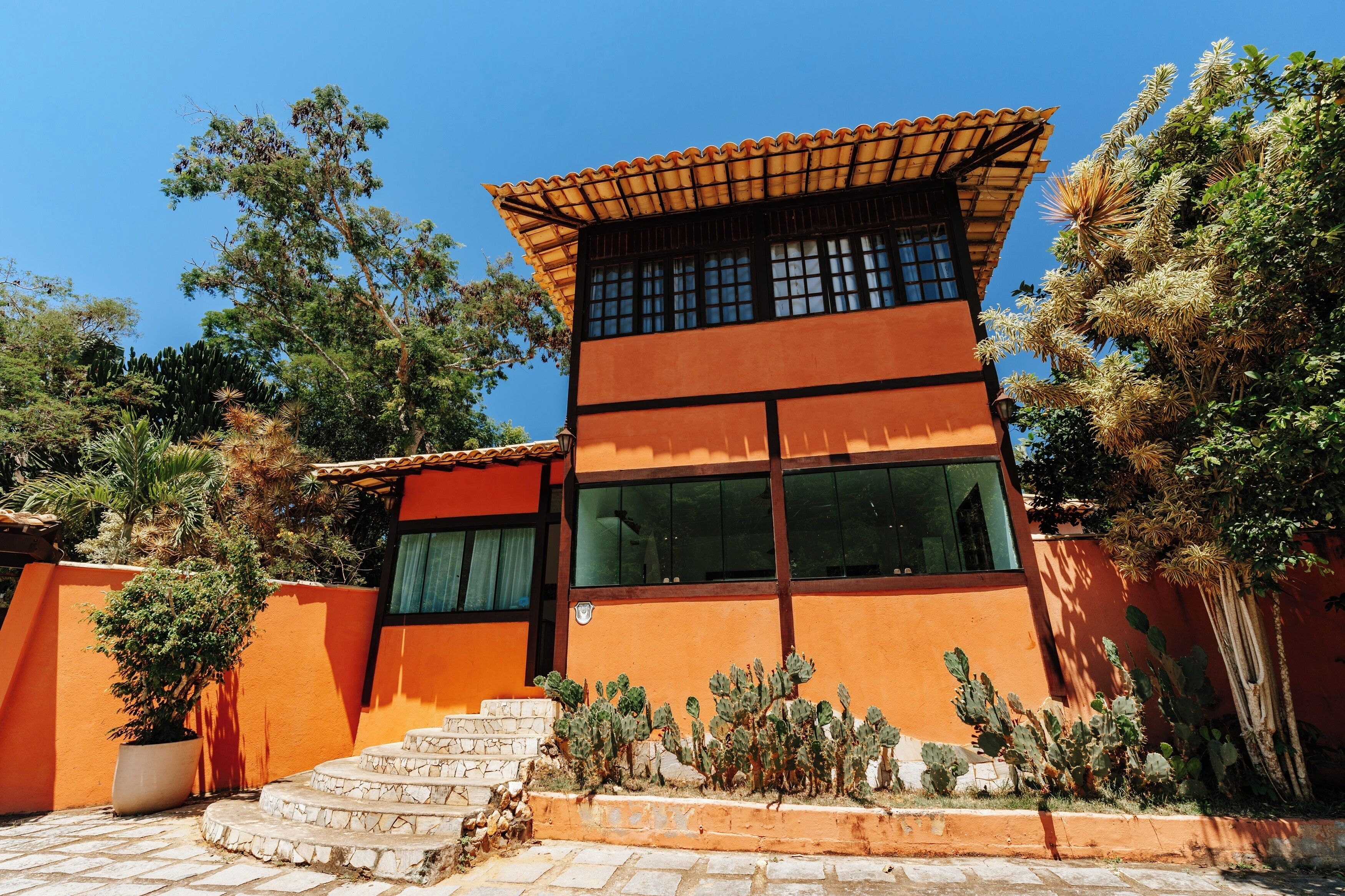 A modern building with a flat roof, large windows, and a staircase leading to the entrance.