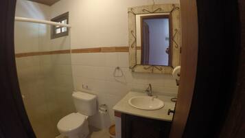 Ein Badezimmer mit Toilette, Waschbecken und Duschbereich.