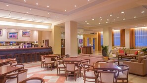 A hotel lobby with a bar, dining area, and seating. - Hellinis Hotel (Corfu)