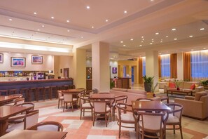 A hotel lobby with a bar, dining area, and seating. - Hellinis Hotel (Corfu)