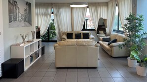 Een moderne woonkamer met een zithoek, een salontafel en een boekenkast.