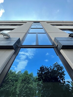 A modern building with large glass windows and a clear view of the sky and trees.