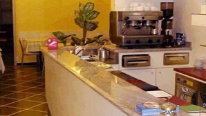 Una cocina con encimera de mármol, cafetera y tostadora.