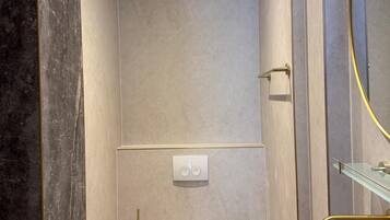 A modern bathroom with a toilet, a sink, and a shower.