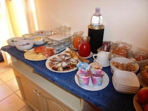 A breakfast buffet with various food items and beverages on a blue countertop. - Casa Famiani Bed & Breakfast (Letojanni)