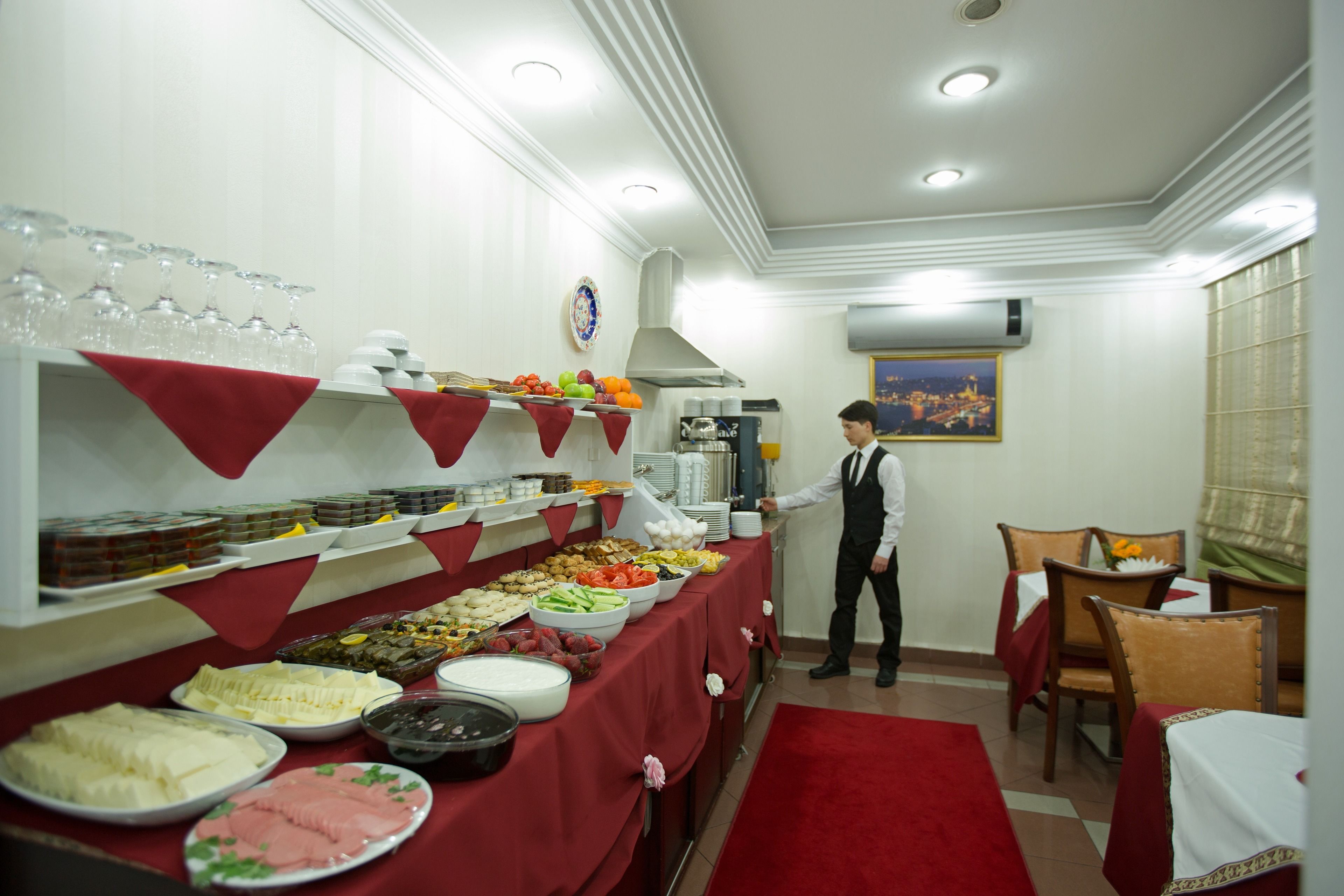 Buffet montado com diversos alimentos e uma pessoa servindo.