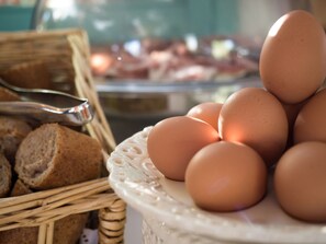 Una cesta de mimbre con pan y un plato de huevos.