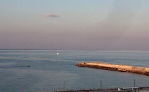 A coastal scene with a lighthouse, a small sailboat, and a rocky breakwater with the inscription "CICCIO IN ETERNO!". - OrtigiaSeaView Bed & Breakfast (Syracuse)