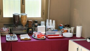 A breakfast buffet setup with various food items and utensils. - B&B Hotel Bicocca (Milan)