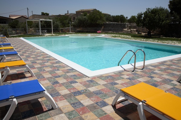 Alberca al aire libre y camastros