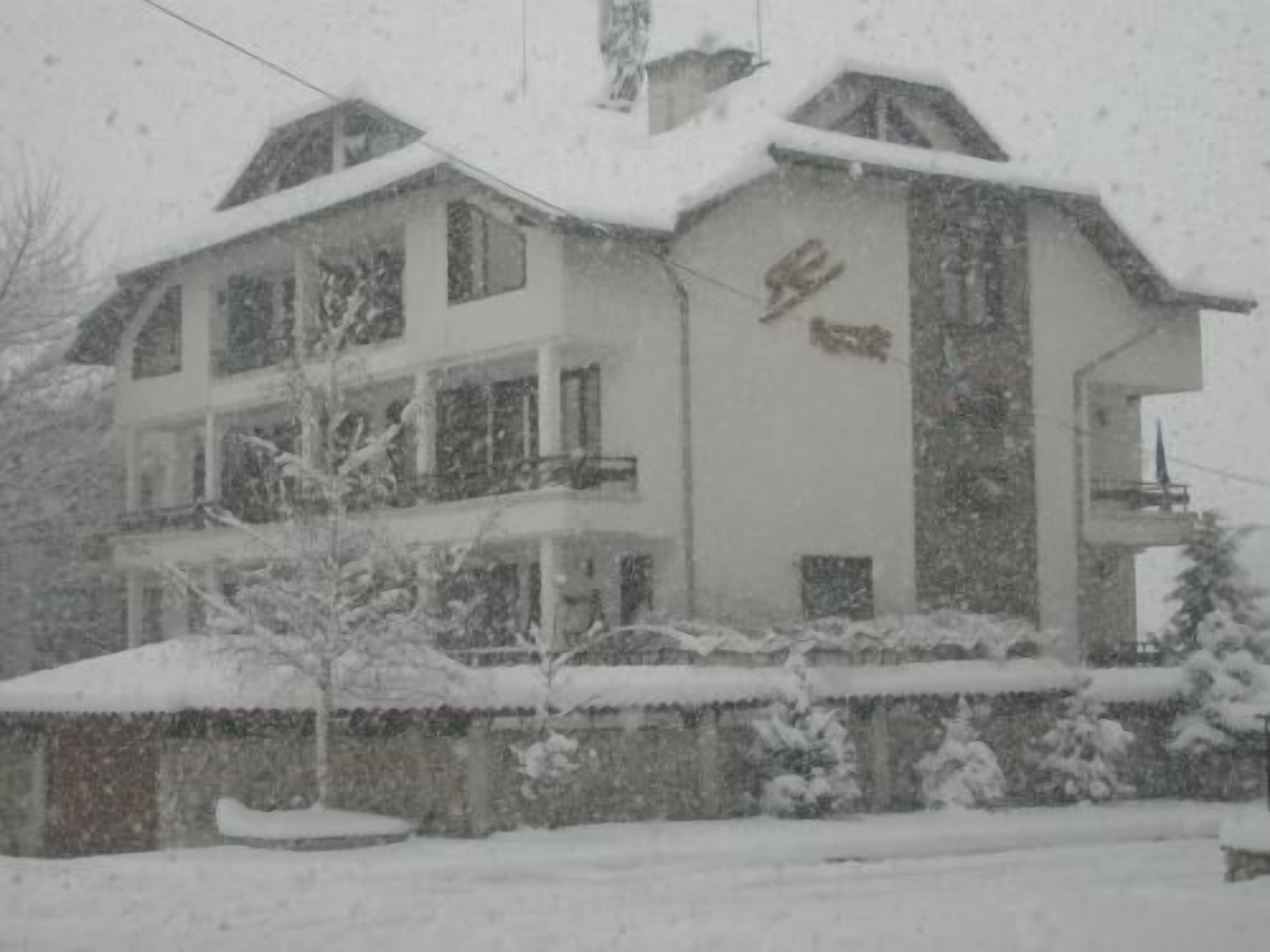 Un edificio de varios pisos con techo nevado y fachada.