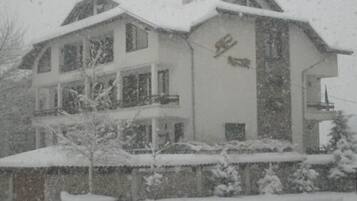 Un edificio de varios pisos con techo nevado y fachada.