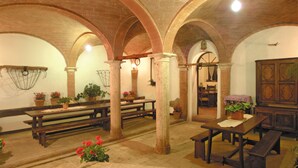 Un intérieur rustique avec des plafonds en arc de cercle, des bancs en bois et des plantes en pot.